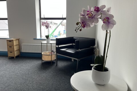 a room with a white table and a purple flower