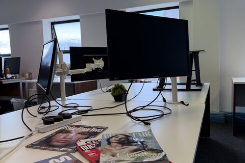 a desk with a computer and magazines on it