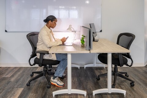 a woman sitting at a desk using a phone