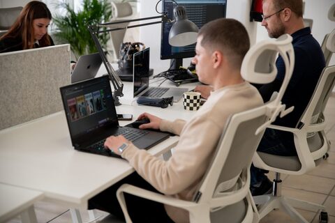 a group of people sitting at a table using a laptop