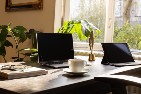 a desk with a laptop computer sitting on top of a table