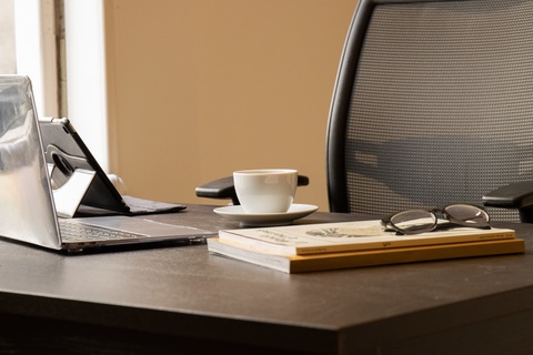 a desk with a laptop computer sitting on top of a table
