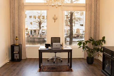 a room filled with furniture and vase of flowers on a table