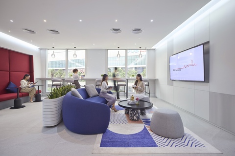 a group of people sitting in a room with a large screen