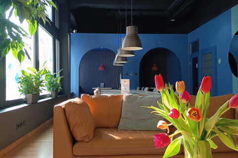 a vase of tulips in a room with a couch and a table