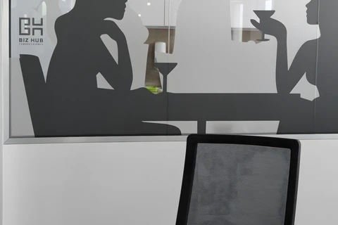 a person sitting at a desk in front of a mirror