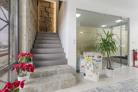 a staircase with boxes and plants in front of a stone wall
