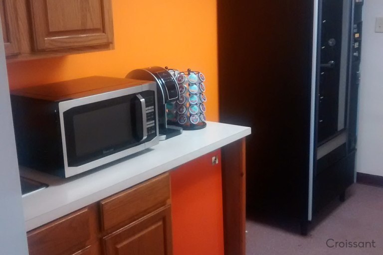 a kitchen with a microwave oven sitting on top of a refrigerator