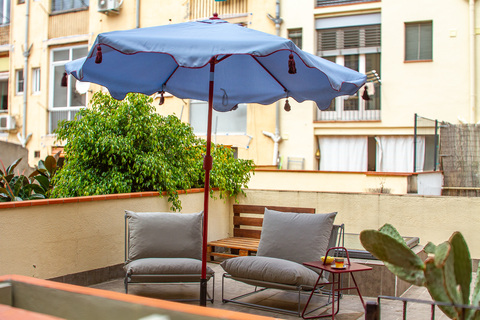 a patio with a blue umbrella and chairs