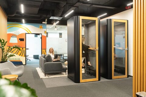 a woman sitting in a chair in a room with a phone booth
