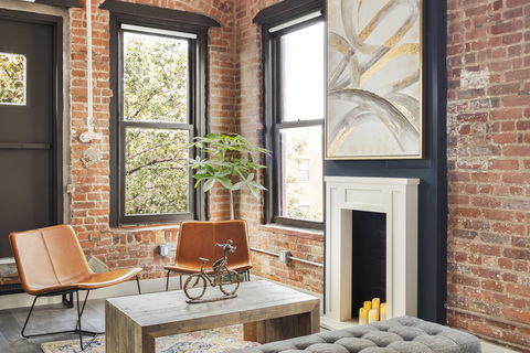 a living room with a fireplace in front of a brick building