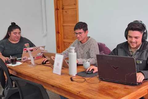 a group of people sitting at a desk with a laptop