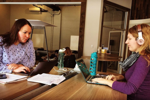 a woman sitting at a table using a laptop