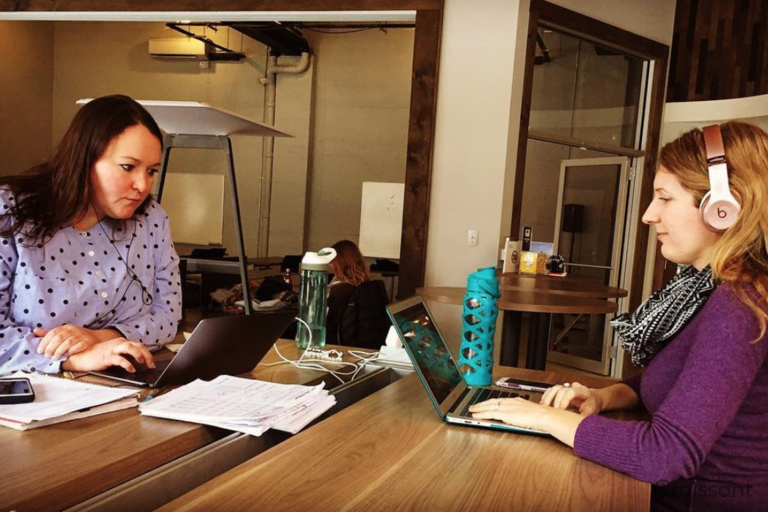 a woman sitting at a table using a laptop