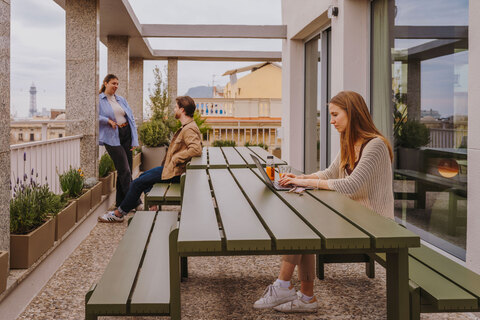a group of people sitting at a table in front of a building