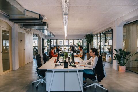 a group of people sitting at a desk in an office