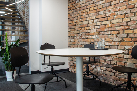 a table and chairs in a room with brick walls
