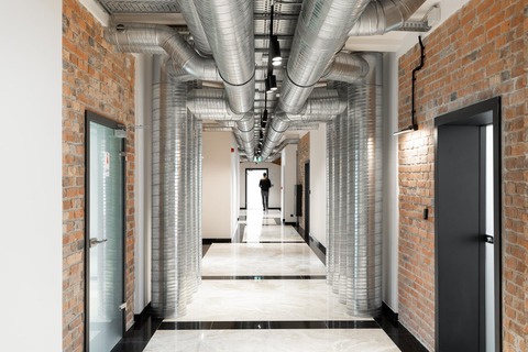a man standing in a hallway with pipes