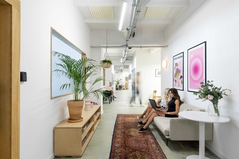 a group of people sitting on a couch in a room with a rug and a rug