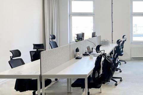 a room with white desks and chairs