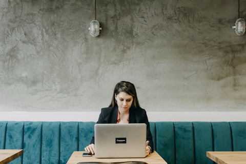 a woman sitting at a table using a laptop