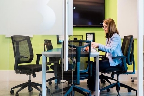 a person sitting at a desk in an office chair