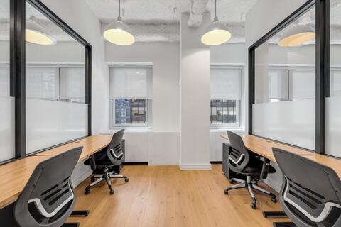 a desk with a computer and a chair in a room