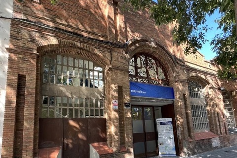 a brick building with trees in the background