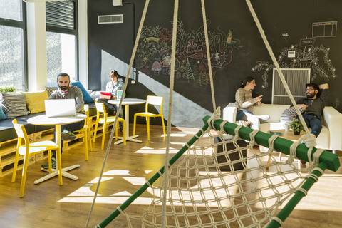 a group of people sitting at a table with an umbrella