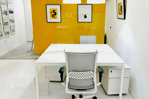 a white desk with a chair and a glass partition