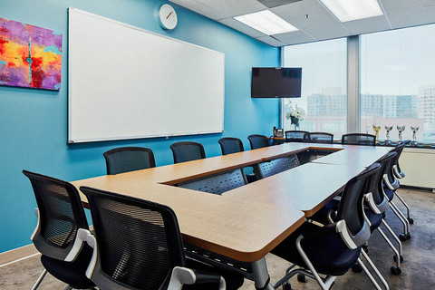 a desk with a computer and a chair in a room
