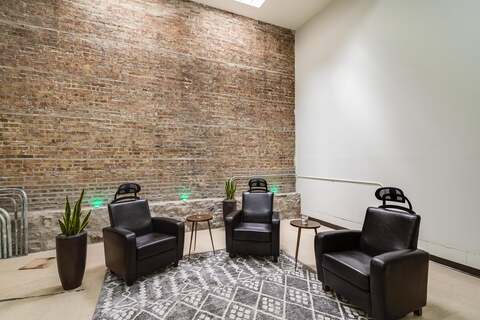 a room with chairs and a brick wall