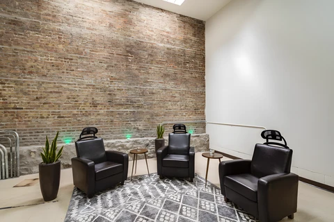 a room with chairs and a brick wall