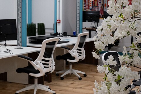 a white flowers next to a desk and chairs