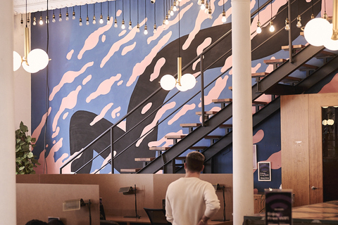a man standing in a room with a staircase and a wall with lights