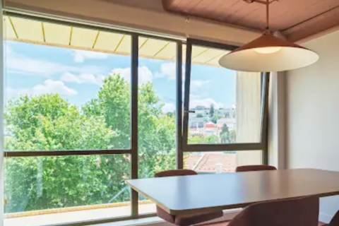 a table and chairs in a room with windows