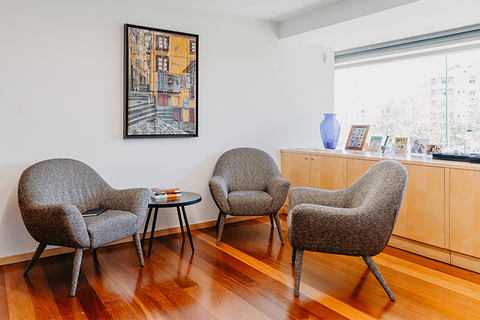 a living room with a desk and looking at the camera