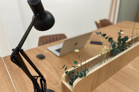 a desk with a lamp and a planter on it
