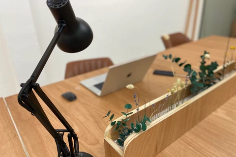 a desk with a lamp and a planter on it