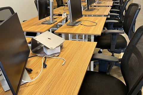 a desk with a laptop computer sitting on top of a chair