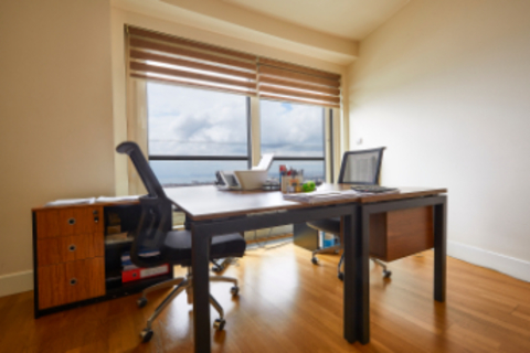 a room with a wooden floor next to a window