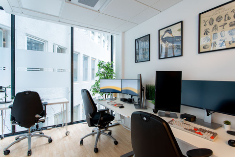 a room with two computers and a large window