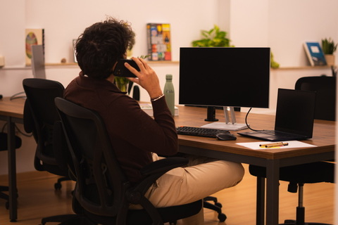 a person sitting at a desk in front of a computer