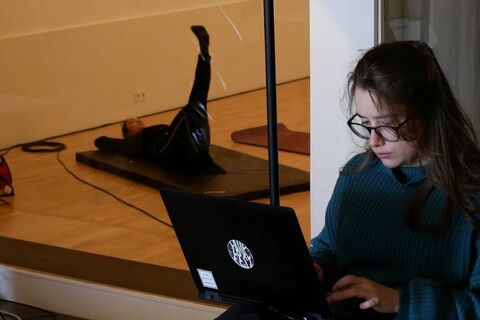 a woman sitting at a table using a laptop computer