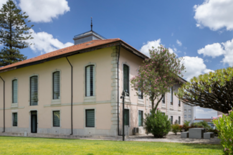 a large brick building with grass in front of a house