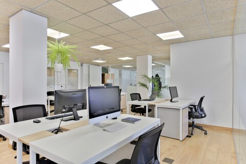 a desk with a computer and a chair in a room