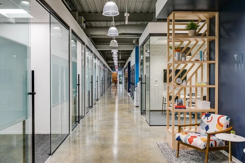 a hallway with glass walls and a chair