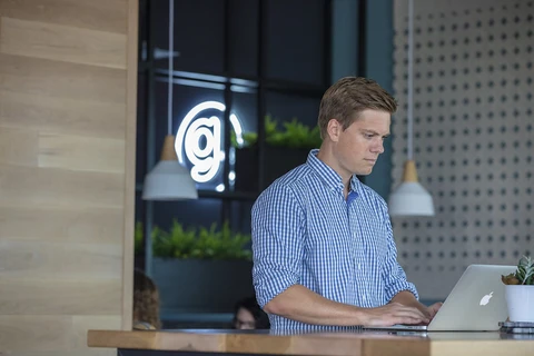 a man sitting at a counter using a laptop