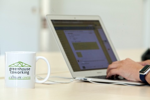 a person using a laptop computer sitting on top of a table