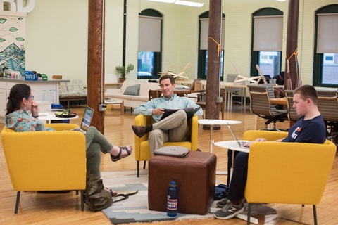 a group of people sitting at a table with a laptop